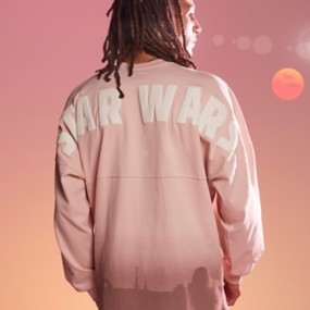 Back of a man wearing a blush-colored Star Wars Spirit Jersey with Star Wars written across the shoulders and the skyline of Tatooine along the bottom of the shirt.