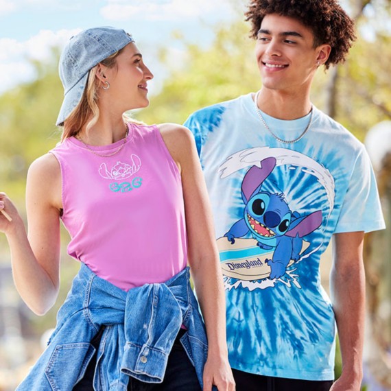 Blonde young woman with a backwards baseball cap wearing a mauve Stitch tank top standing next to a brunette young man wearing a blue tie-dye Stitch t-shirt.