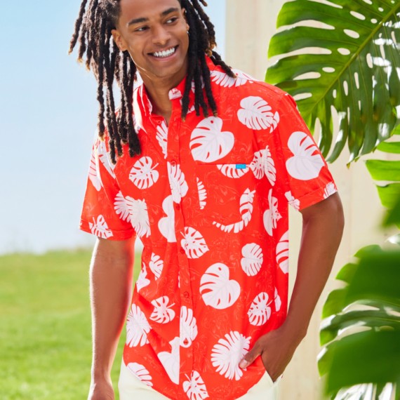 Young man standing outside wearing a Lilo and Stitch red and white patterned Hawaiian shirt.