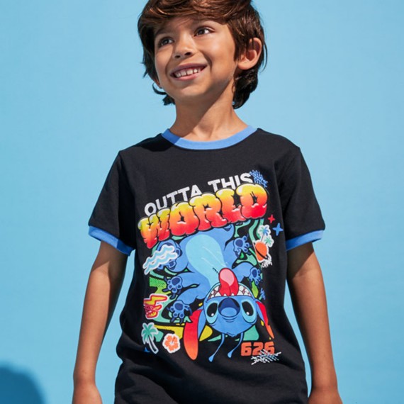 Young boy wearing a black and blue Stitch t shirt with text "OUTTA THIS WORLD".